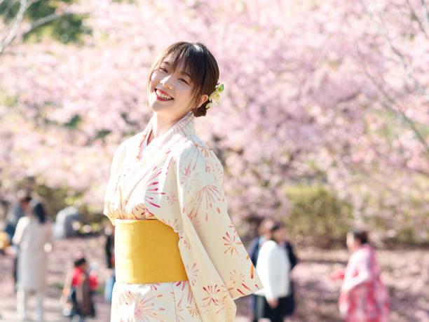 portrait d’une belle jeune fille chinoise en kimono japonais posant avec des fleurs de cerisier en fleur dans le jardin printanier, la beauté, l’émotion, le style de vie, l’expression et le concept de personnes. - cherry blossom flower head spring flower photos et images de collection