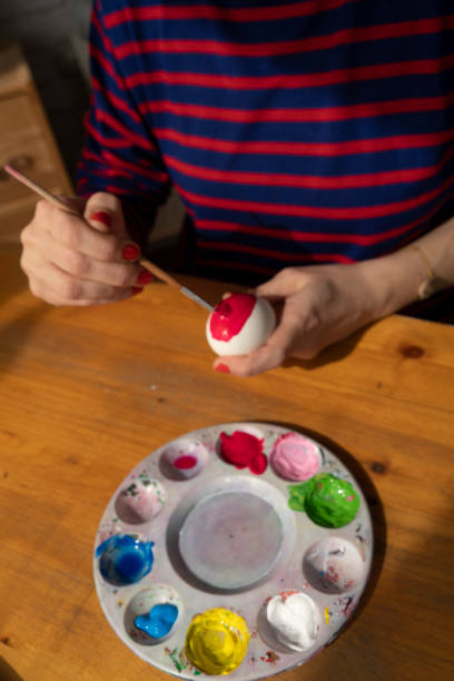 istock Woman painting Easter Egg and preparing for Easter holiday celebration 1472943503