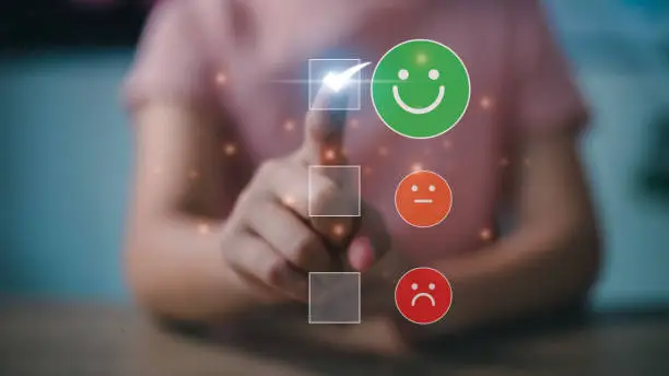 Photo of Women choosing on the happy Smile face icon, a positive mindset selection. Customer service and Satisfaction concept, feedback, review, feedback, best quality.