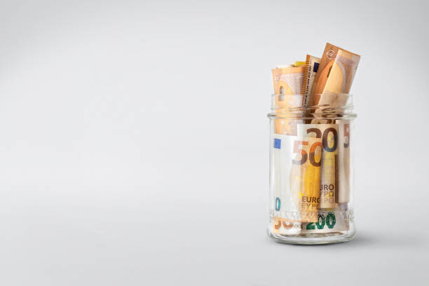 istock Euro bills in glass jar on a white background with copy space. Saving money concept 1472944414