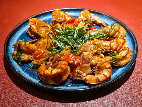 Pan fried tiger prawn with basil (香煎九層塔大虎虾) is a popular dish that involves frying large, succulent tiger prawns with fragrant basil leaves, creating a savory and aromatic flavor combination.