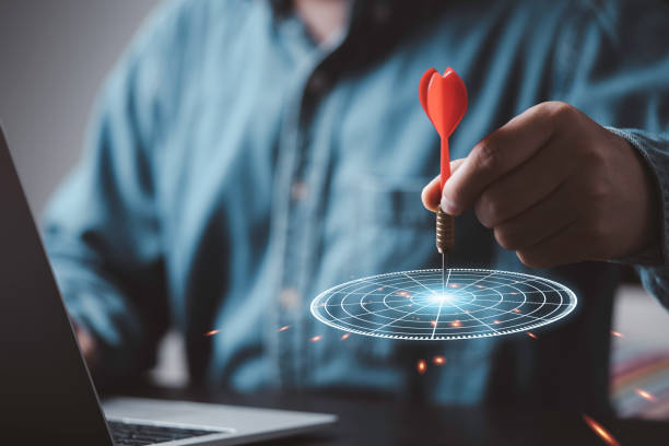 istock Businessman throwing red arrow dart to virtual target dart board, Setup objectives and target for business investment concept. 1472947267