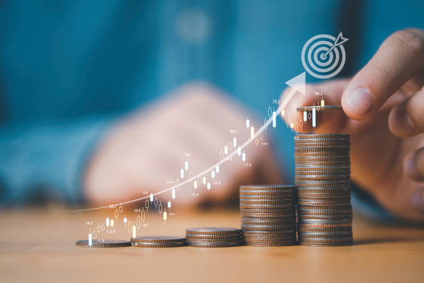 istock Businessman putting coins stacking with increasing graph and dartboard  for increase financial interest rate and business investment growth from dividend , Investor setup business objective target. 1472947925