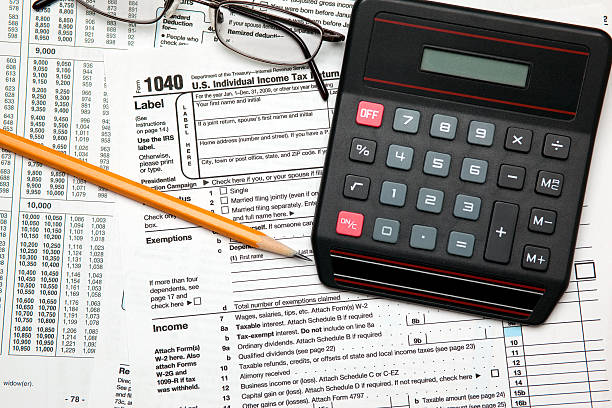 istock Tax time - U.S. 1040 return with pencil, glasses 147294795