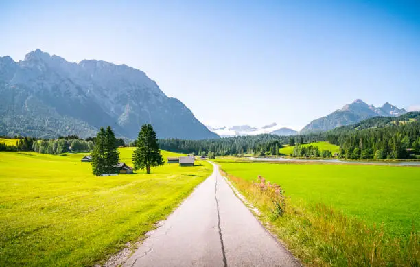 Beautiful mountain road in Mittenwald Germany alps. Panorama view field and meadow. Idyll hiking forest and nature.