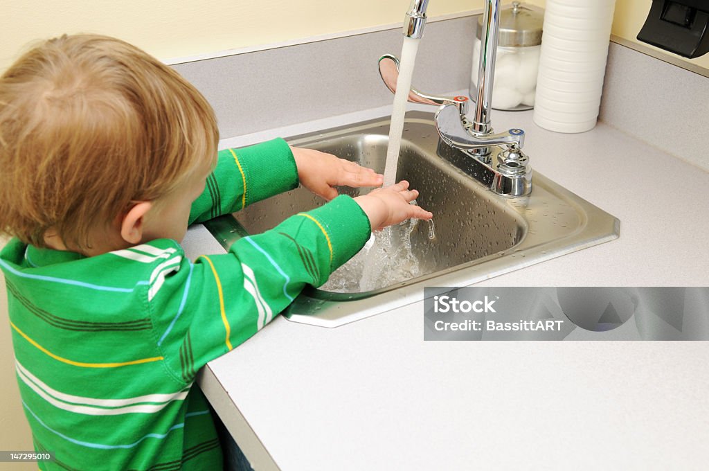 Getting Clean A boy washes his hands at a doctors office Bathroom Stock Photo