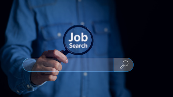 Job search concept. Man using magnifying glass Search on virtual screen for information. find a job, unemployment, recruitment, job interview, data Search Technology Search Engine Optimization.