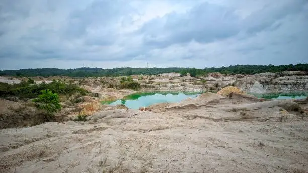 View of the vast plains of the former tin mining area on Bangka Island, there is a blue lake in the middle, and a row of tropical green forests at the end
