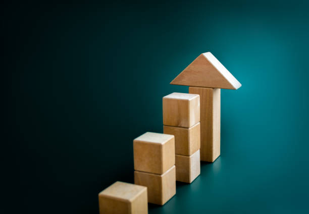 istock Big arrowhead wooden on increase cube blocks bar graph chart steps on dark blue background with copy space. Investment, income, trends, inflation, business growth, economic improvement concepts. 1472958239