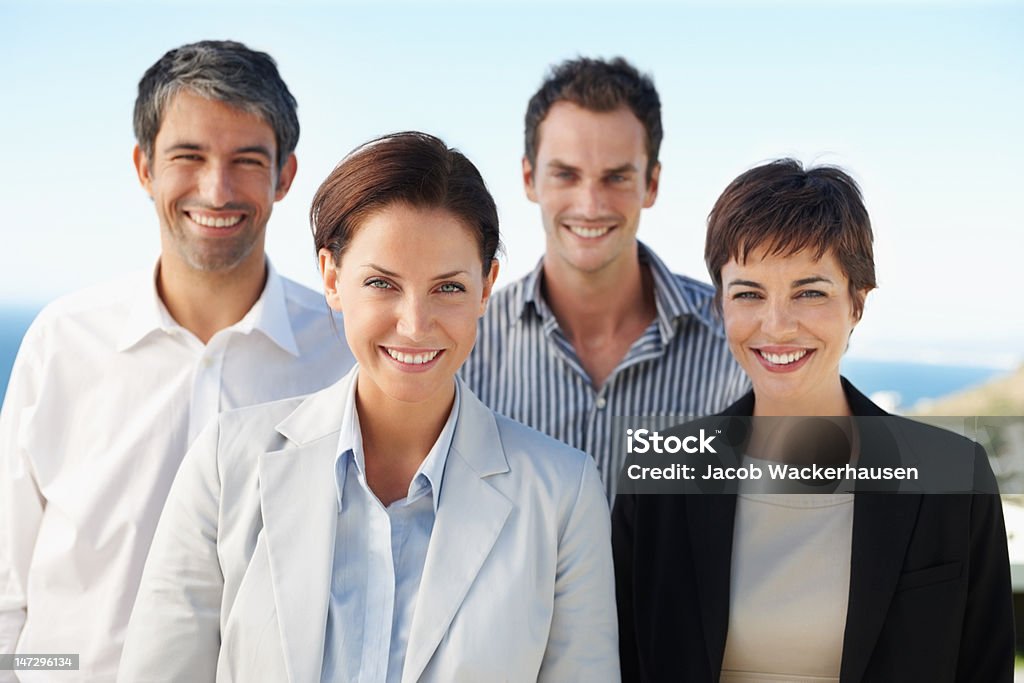 Colegas de trabalho em pé juntos e sorrindo - Foto de stock de 20 Anos royalty-free