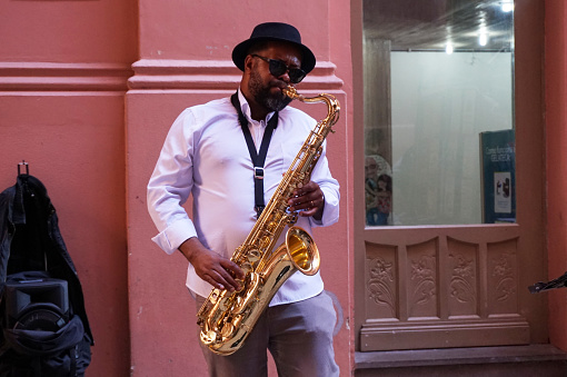Street musician playing sax in CCMQ the historic district city of Porto Alegre, RS, Brazil - June 22, 2019.