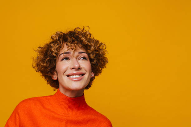 istock Middle-aged woman looking up isolated over yellow background 1472963340