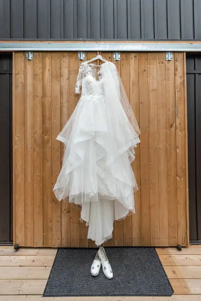 A gorgeous white princess style wedding dress with layers of chiffon ruffles cascading from the waist line along with the bride's canvas bumblebee adorned shoes.