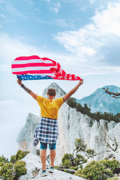 istock Man with American flag on the top on mountain 1472965930