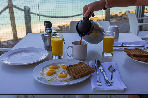 Glass of orange juice and oranges outdoors on a wooden table with nature background