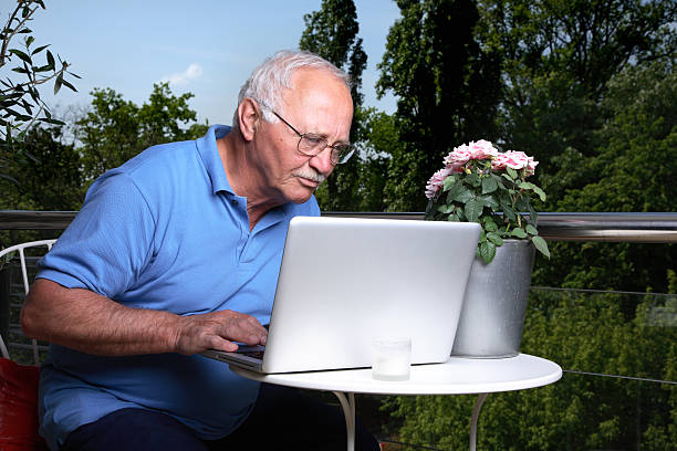 старший мужчина, используя ноутбук - toothfairy стоковые фото и изображения