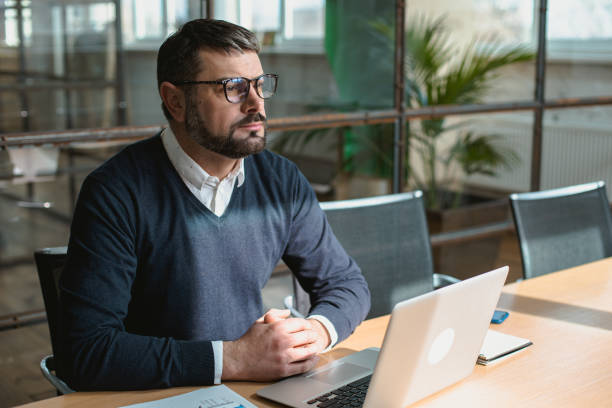 istock Adult man sitting in the office and using laptop 1472968798