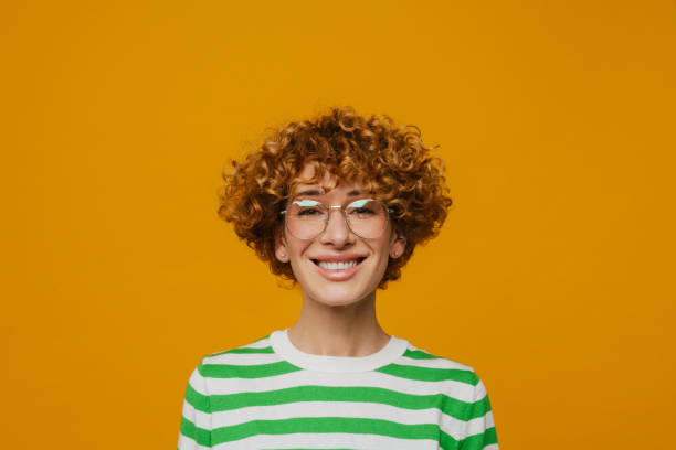 istock Curly ginger woman in eyeglasses smiling and looking at camera 1472969352