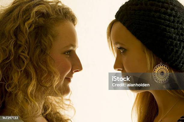Two Girls In Close Up Looking At Each Other Stock Photo - Download Image Now - Adult, Black Color, Blank Expression