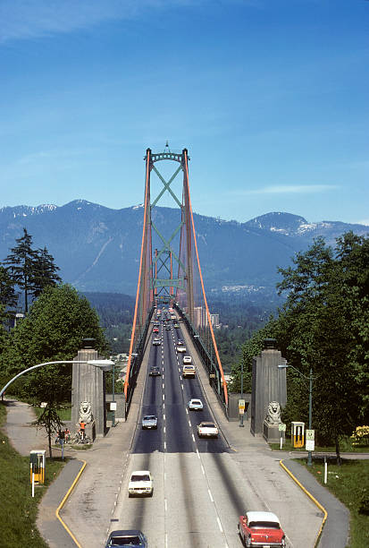 Lion's Gate Bridge, British Columbia, circa 1975 Lion's Gate Bridge in Vancouver, British Columbia. Lots of copy space in the sky, as well as period-specific cars from the mid-70s driving across the bridge. hearkencreative stock pictures, royalty-free photos & images