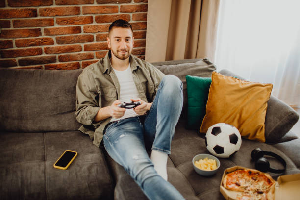 istock High-angle view of a guy playing a video game at home 1472972207