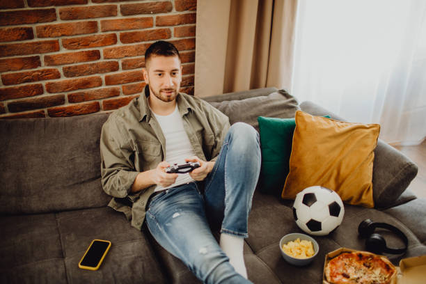 istock High-angle view of a guy playing a video game at home 1472972214