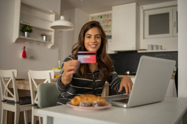 istock Cheerful  woman doing online shopping 1472972819