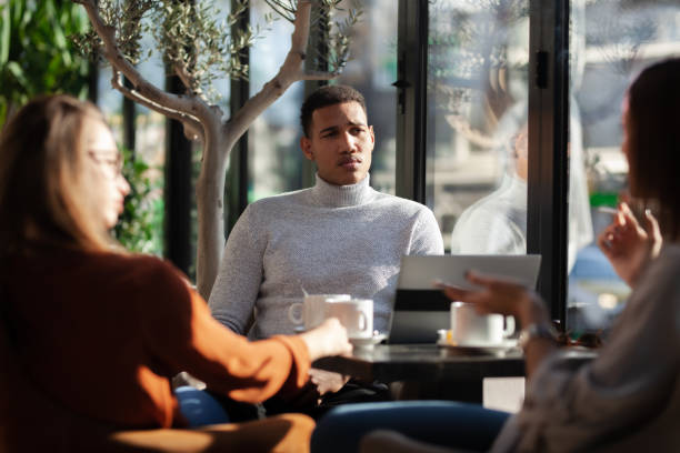istock Three friends in a restaurant talking smiling and drinking tea. Business colleagues having a meeting after work or during coffee break at a cafe bar. 1472973487