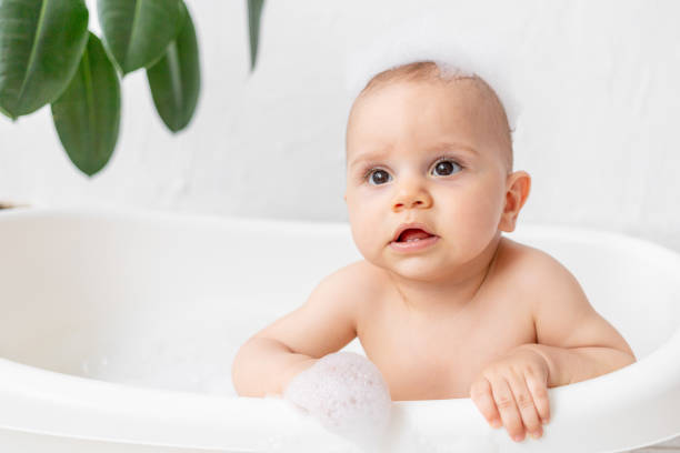 istock A small child boy 8 months old bathes in a bath with foam and soap bubbles, place for text 1472975940
