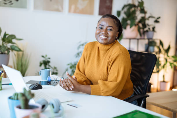 istock African entrepreneur working in office on laptop and looking at camera 1472977358