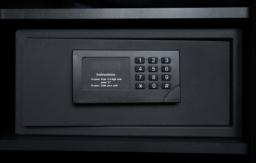 Modern safety locker in a hotel room or at home. Black steel safe box with electronic security lock.