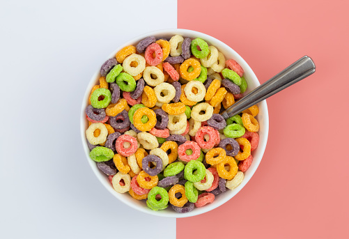 Colored breakfast cereal in a bowl on a colored background, flat lay, children's healthy breakfast, close up.