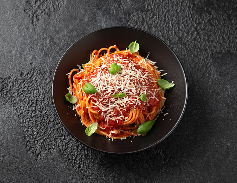 Italian marinara sauce spaghetti pasta served with fresh basil, olives and pecorino cheese.