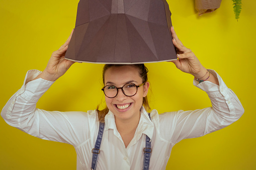 Portrait of a smiling woman holding an origami bear as a wall decoration