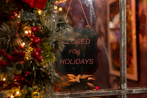 Closed for Christmas holidays in winter time. Shop, store, cafe business closing for vacations. Sign board on window. High quality photo