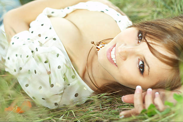 beautiful girl lying down of grass with white dress