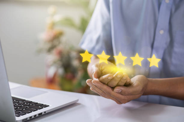 istock Man hand with popup five star icon for feedback review satisfaction service, Customer services best excellent business rating experience online. best quality product and service. 1472984039