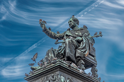 Statue of seated Maximilian I Joseph, the first king of Bavaria on Max Joseph Square in Munich Old Town with pigeons