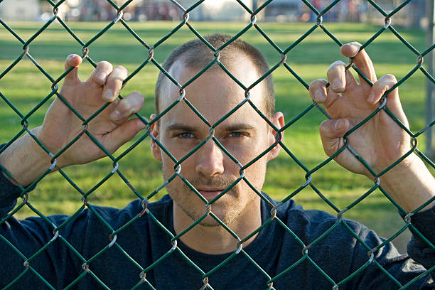 istock Young Man Behind Wire Fence 147298724