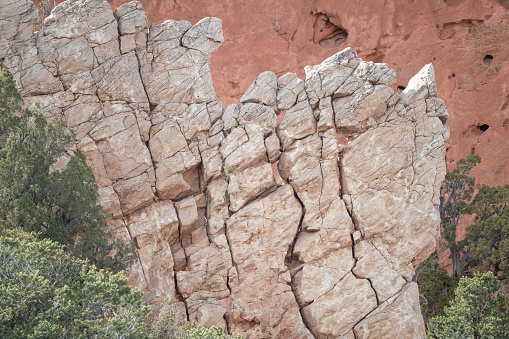 Image of a tall red rock wall towering high above.