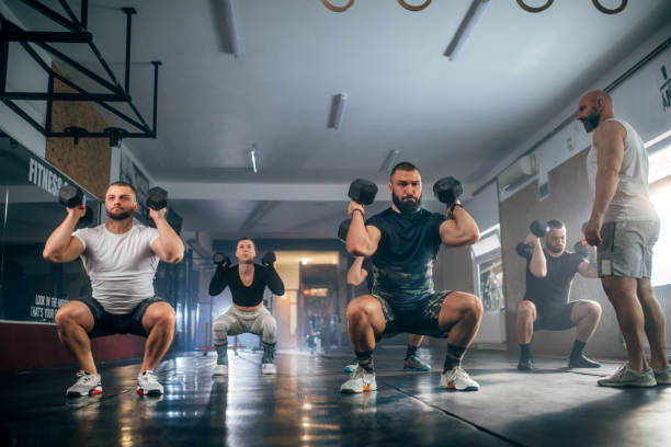 istock Athletic people having cross training with dumbells in a gym 1472988637
