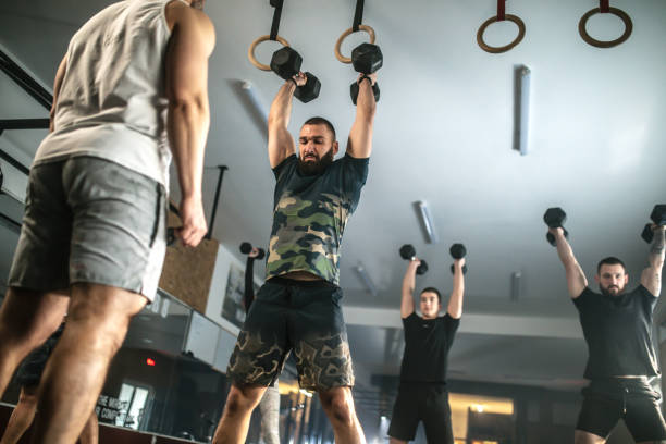 Athletic people having cross training with dumbells ia a gym