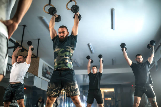Athletic people having cross training with dumbells ia a gym