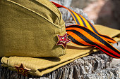 Military cap and St. George ribbon on a wooden stump