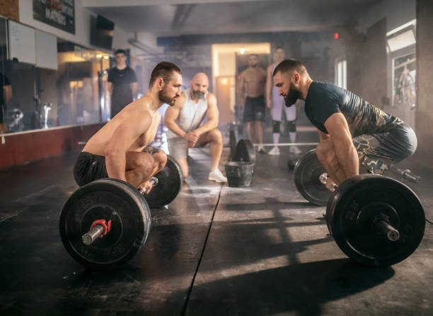 istock Athletic people having cross training with dumbells in a gym 1472989021