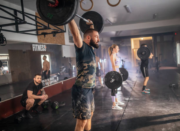 istock Athletic people having cross training with dumbells in a gym 1472989315