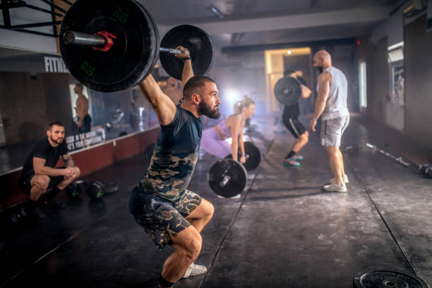 istock Athletic people having cross training with dumbells in a gym 1472989316