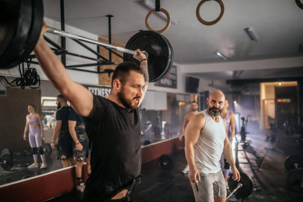 istock Athletic people having cross training with dumbells in a gym 1472989382