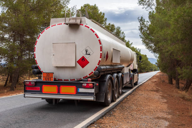트럭의 대시보드와 스티어링 휠이 전경에 있는 땅에 파고 있는 두 컷 사이의 좁은 도로를 운전하는 트럭의 운전 위치에서 본 모습. - fuel tanker truck oil chemical 뉴스 사진 이미지