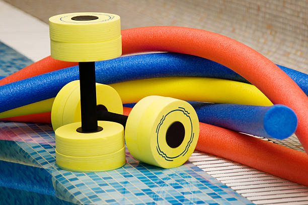 Colorful equipment for water aerobics by a pool stock photo